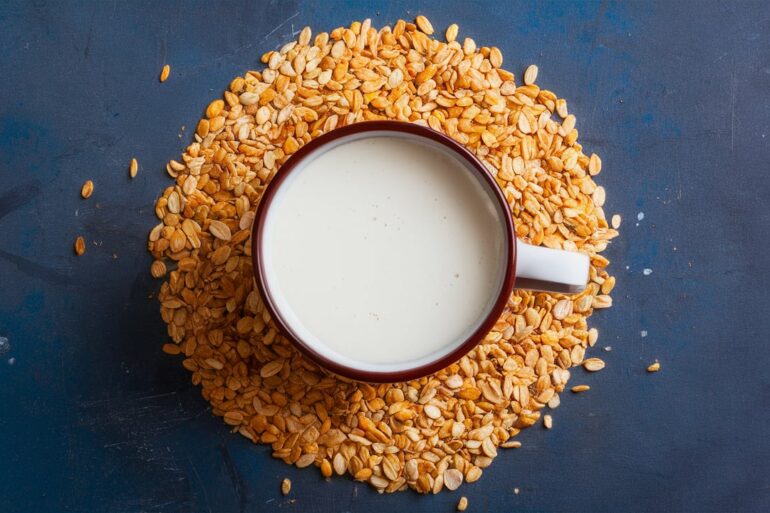 bicchiere di latte avena circondato da avena