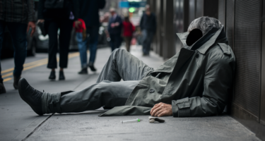 Eroinomane disteso in un marciapiede di una strada metropolitana europea